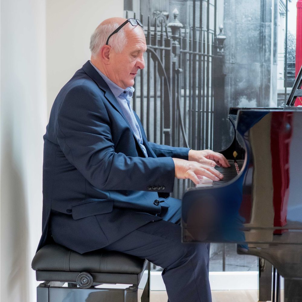 David Bushnell staff photo playing piano