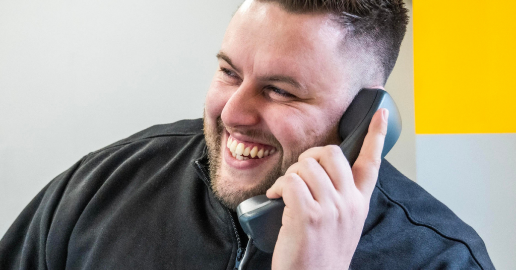 Man holding a wired office phone