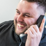 Man holding a wired office phone