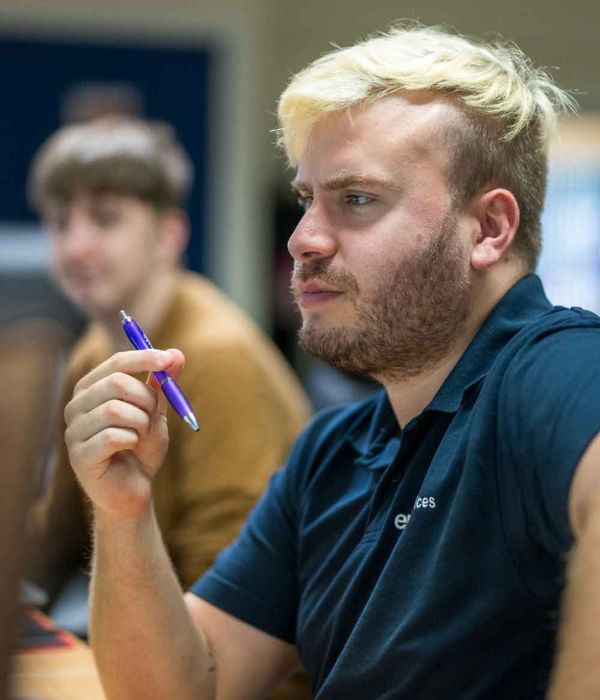 Man holding pen looking at computer