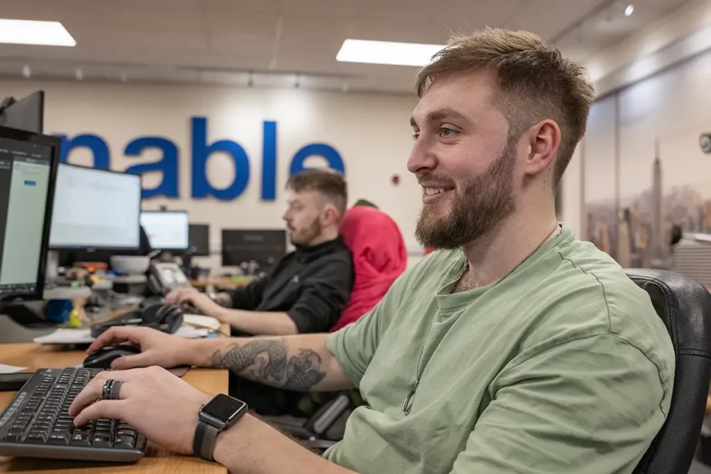 2 men in office working on computer