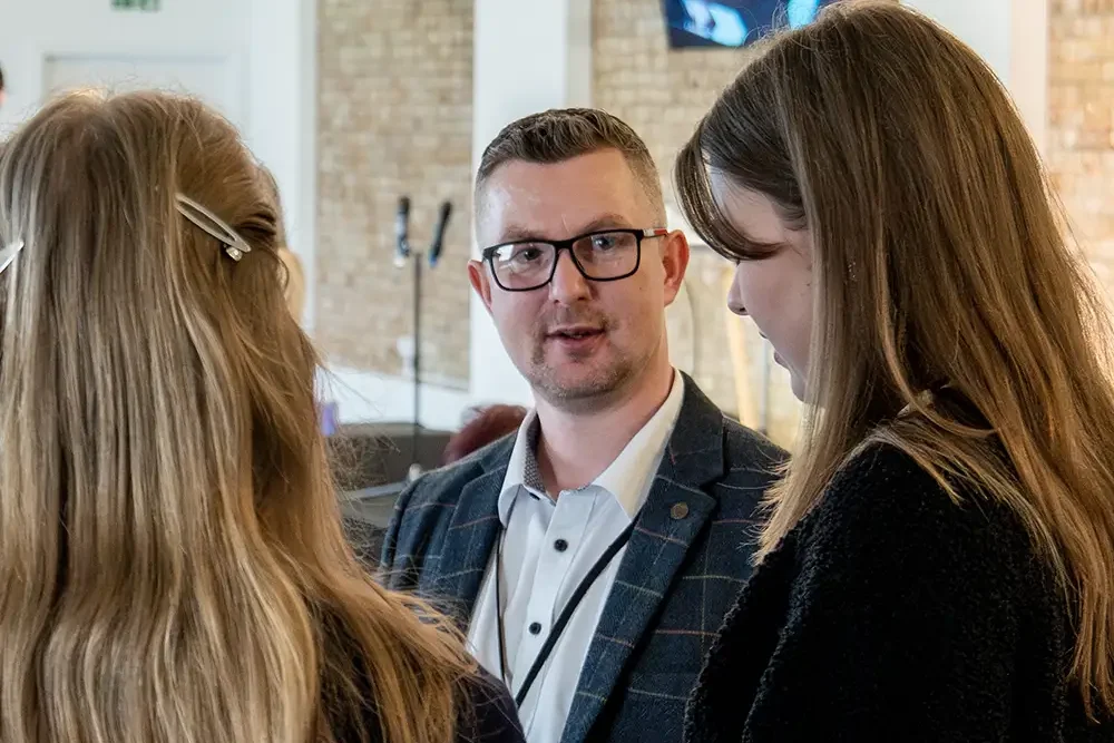 man in suit talking to a group of people