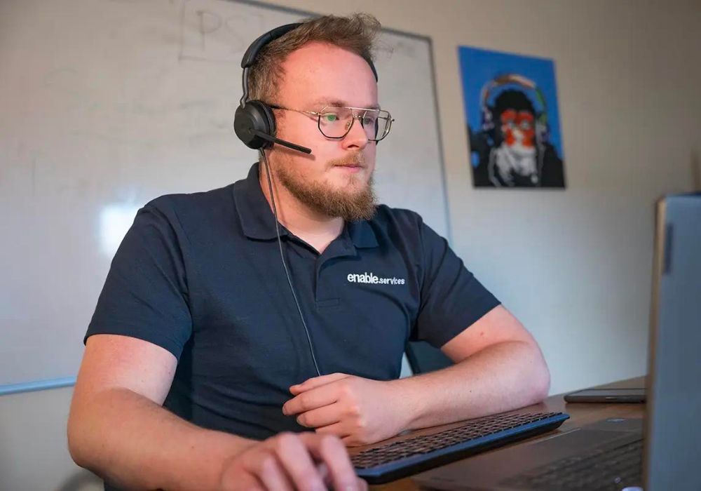 Man wearing headset and working on computer