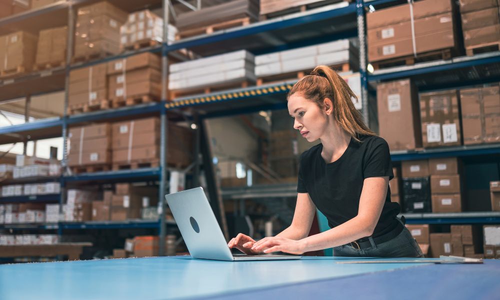 women on laptop in warehouse