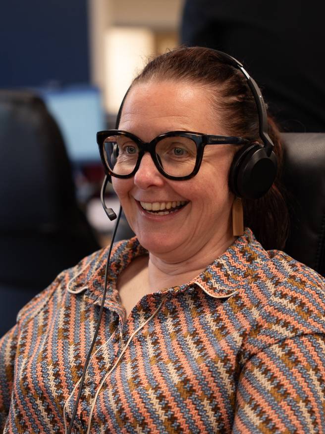 women smiling wearing headset in office