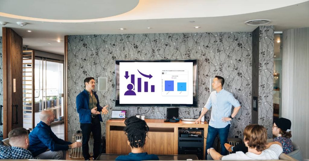 image of a meeting with report charts being shown on screen