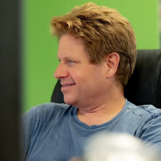 Man in office on computer smiling