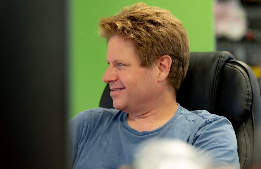 Man in office on computer smiling