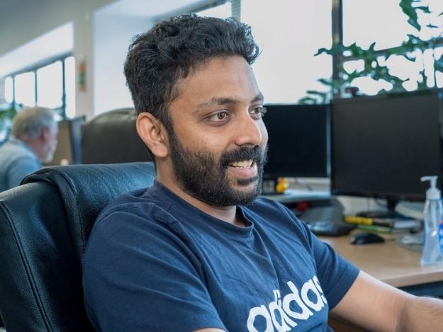 man in office smiling using computer