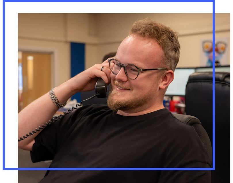 man smiling on holding telephone to his ear