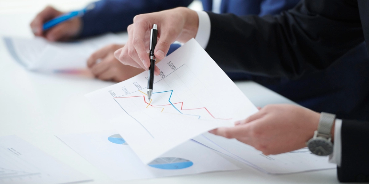 Image of person poitning at paper with pen