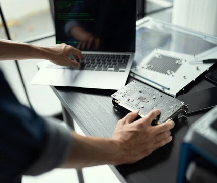 man working on hardware and laptop