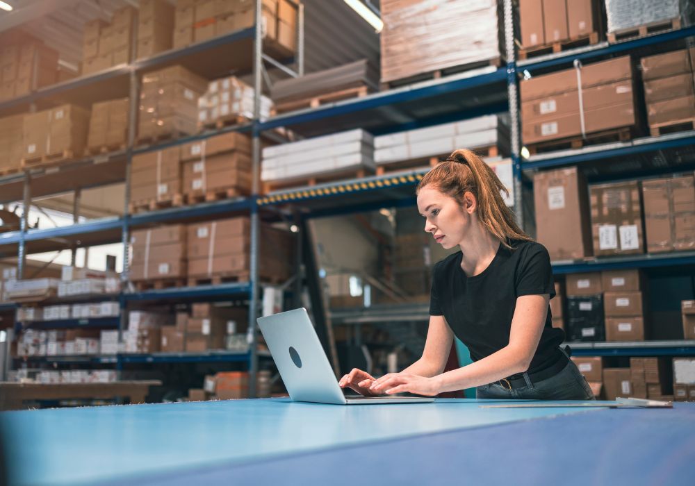 woman using laptop in warehouse